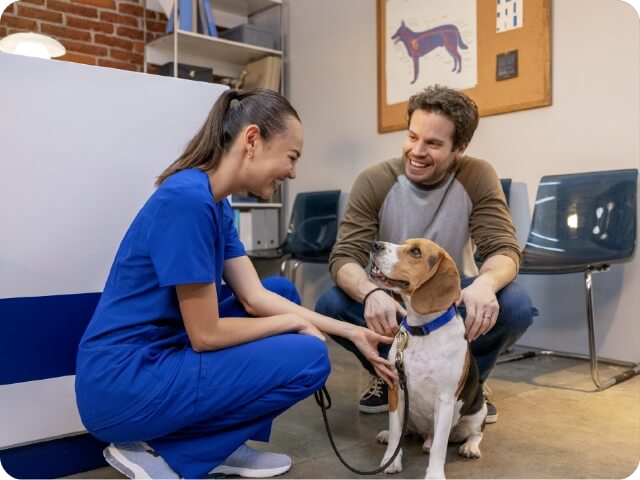 A vet, her client, and a happy dog kneel on the floor | HEARTGARD® Heartworm Protection